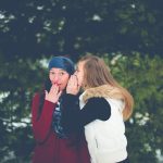 woman-whispering-on-womans-ear-while-hands-on-lips-ben-white