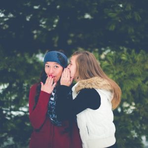 woman-whispering-on-womans-ear-while-hands-on-lips-ben-white